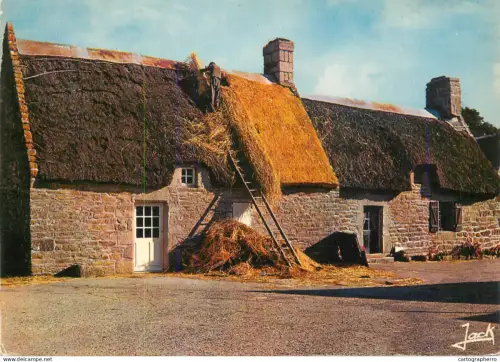 A5674 France Bretagne thatched cottage man repairing the roof