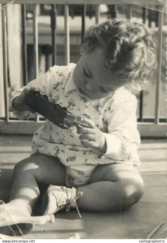 A6099 Postcard photograph of a young child engaging in quiet play with a vintage toy vehicle