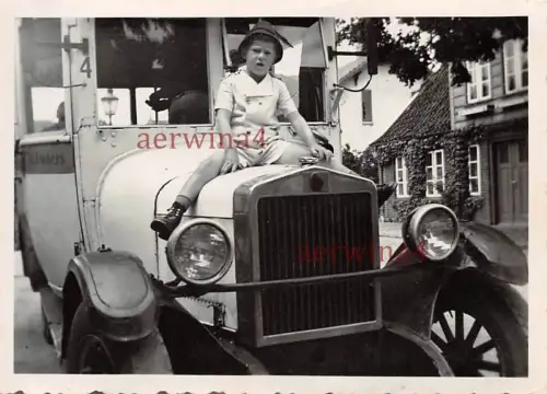 Junge auf Motorhaube auf alten Omnibus