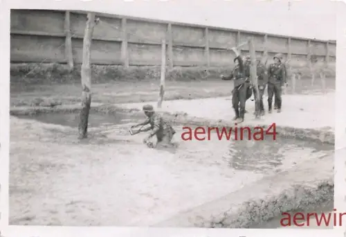 Deutscher Soldat beim Hindernis Übung im Schlamm Graben