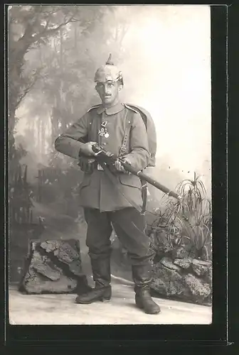 Foto-AK Portrait deutscher Infanterist in Uniform mit Pickelhaube, Gewehr 88 und Orden EK II