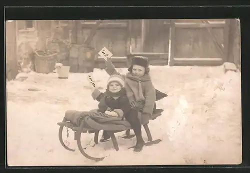 Foto-AK zwei kleine Kinder sitzen auf einem Schlitten