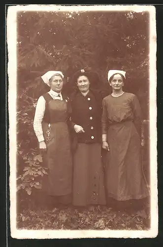 Foto-AK Dame, Arm in Arm mit zwei Frauen mit weisser Haube
