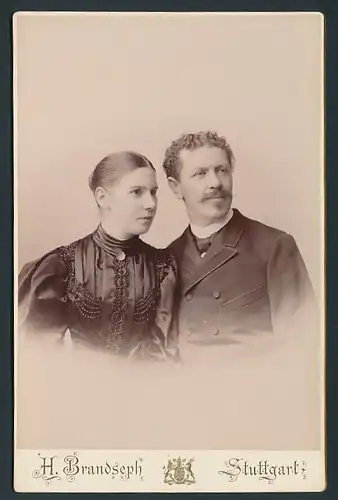 Fotografie H. Brandseph Stuttgart, Portrait eines jungen Paares, Frau mit Haarknoten, Mann mit Schnurrbart