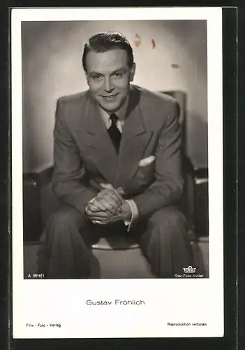 AK Schauspieler Gustav Fröhlich lächelnd in Sessel sitzend porträtiert