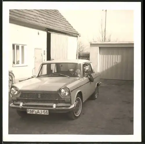 Fotografie Auto Fiat, Knabe sitzt in Limousine, PKW vor einer Garage