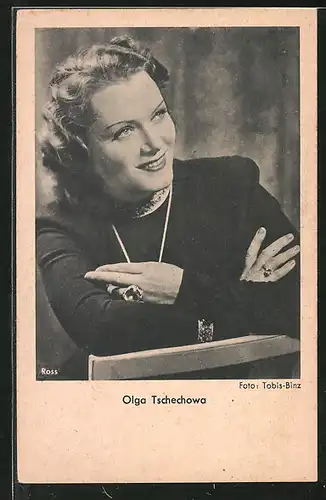 AK Schauspielerin Olga Tschechowa lächelnd über Stuhllehne schauend