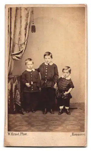 Fotografie W. Ernst, Hannover, Portrait dreier Brüder an einem Vorhang
