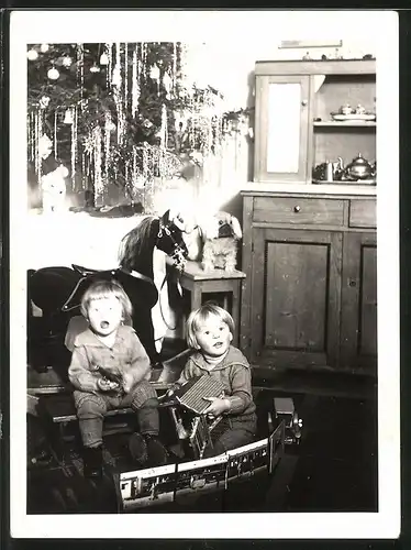 Fotografie Weihnachten, Kinder spielen mit Blechauto, Spielzeug-Pferd steht am Weihnachtsbaum
