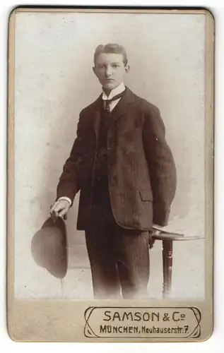 Fotografie Atelier Samson & Co., München, Portrait junger Mann im Anzug mit Hut