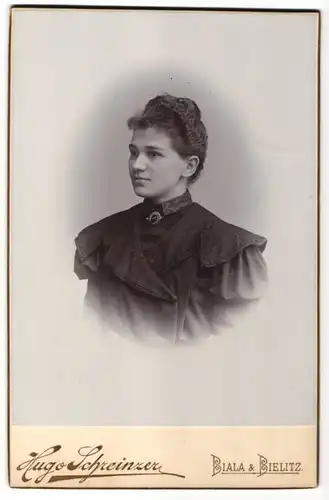 Fotografie Hugo Schreinzer, Biala-Bielitz, Portrait junge Dame im schwarzen Kleid mit Brosche