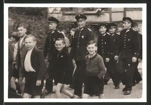 Fotografie DDR-KVP, Kasernierte Volkspolizei, Grenzer in Uniform nebst Knaben im Marsch