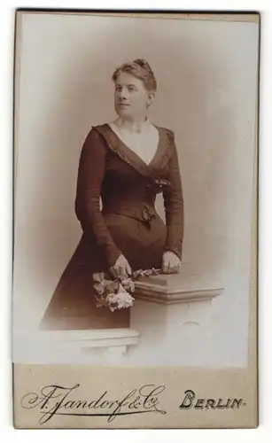 Fotografie A. Jandorf & Co., Berlin, Dame mit Blumenstrauss trägt schwarzes Kleid