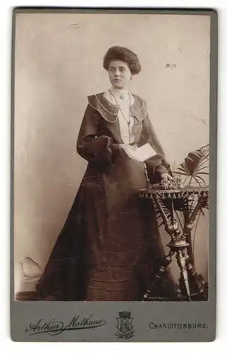Fotografie Arthur Mathaus, Berlin-Charlottenburg, Dame mit Buch im modischen Kleid