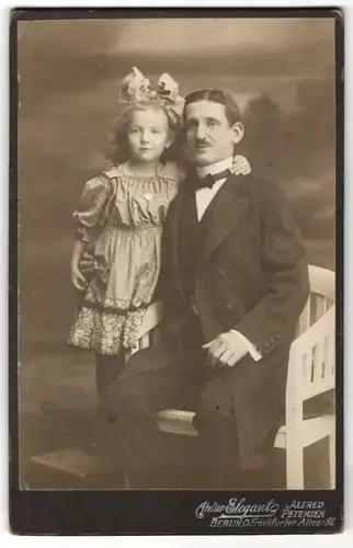 Fotografie Alfred Petersen, Berlin-O, Portrait stolzer Vater und Tochter mit Haarschleife