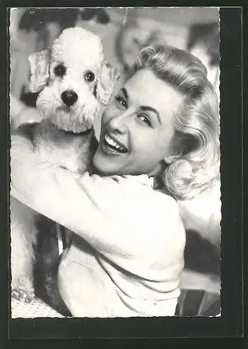 AK Schauspielerin Bibi Johns lächelnd mit Hund auf dem Arm