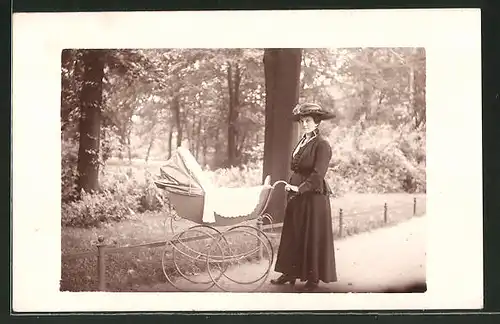 Foto-AK Frau steht mit ihrem Kinderwagen im Park