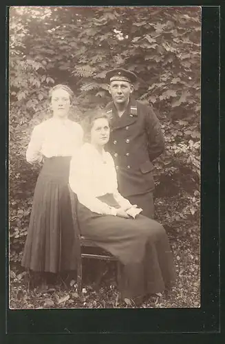 Foto-AK Matrose in Uniform mit Mützenband U-Boot-Flottille steht neben zwei jungen Damen