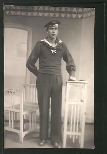 Foto-AK Matrose in Uniform steht an einem Tisch, U-Boot-Fahrer