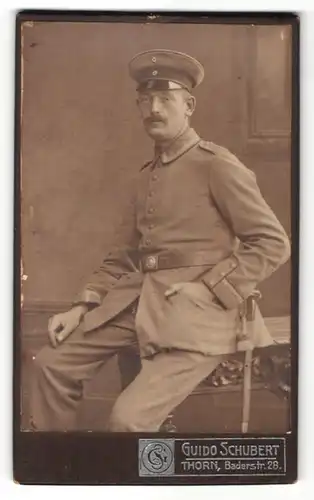 Fotografie Guido Schubert, Thorn, Portrait Soldat in Uniform sitzt auf einem Tisch