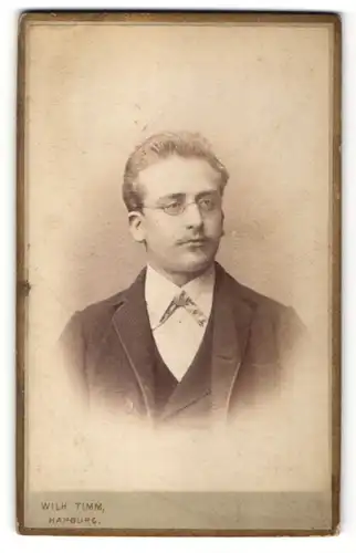 Fotografie Wilh. Timm, Harburg, Portrait eleganter Herr mit Brille