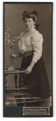 Fotografie C. F. Beddies & Sohn, Braunschweig, Portrait junge Frau mit Blumenvase