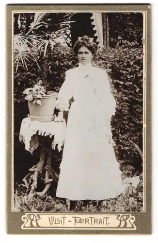 Fotografie Visit Portrait, Ort unbekannt, Portrait junge elegante Frau vor einer Hecke