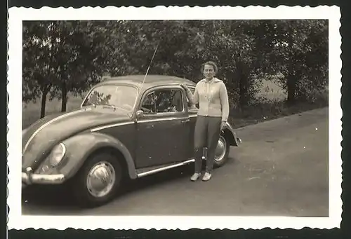 Fotografie Auto VW Käfer, junge Frau steht neben Volkswagen PKW