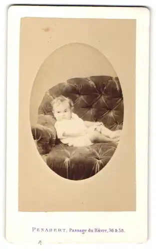 Fotografie Penabert, Paris, kleines Mädchen im weissen Kleid im Sessel liegend