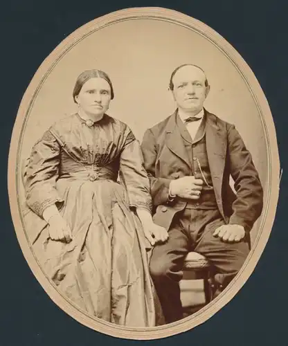 Fotografie Paar im feinen Zwirn posiert sitzend im Foto-Atelier