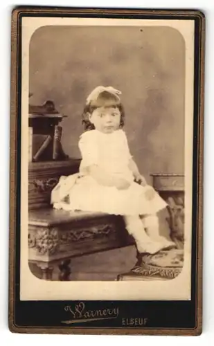 Fotografie Warnery, Elbeuf, niedliches kleines Mädchen mit Haarschleife im weissen Kleid