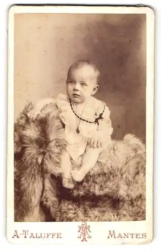 Fotografie A. Taluffe, Mantes, niedliches Baby auf Felldecke sitzend