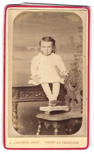 Fotografie J. Laporte, Vitry-le-Francois, Portrait kleines Mädchen auf Tisch sitzend