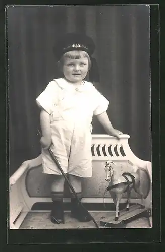 Foto-AK Kleinkind mit Matrosenmütze und Holzpferd auf Rädern