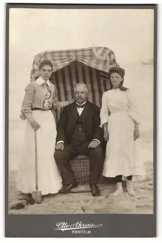 Fotografie Otto Ahrens, Ribnitz i/M, Ansicht Ribnitz i/M, bürgerlicher Herr mit zwei Mädchen am Strand, Strandkorb