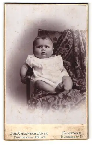 Fotografie Jos. Ohlenschläger, Konstanz, niedliches Baby im weissen Kleid
