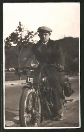 Foto-AK junger Mann mit Schiebermütze auf Motorrad