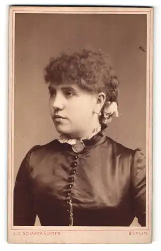 Fotografie J. C. Schaarwächter, Berlin, hübsche junge Frau mit lockigem Haar und Brosche am Kragen