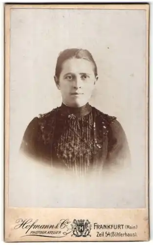 Fotografie Hofmann & Co, Frankfurt / Main, Portrait junge hübsche Frau in edler Bluse mit Spitze und Brosche