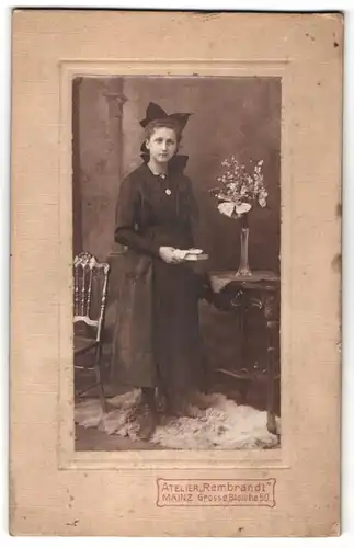 Fotografie Atelier Rembrandt, Mainz, junge hübsche Dame im schwarzen Kleid und Haarschleife