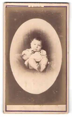 Fotografie E. Baron, Paris, niedliches dunkelhaariges Baby im weissen Kleidchen