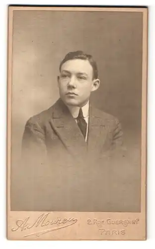 Fotografie A. Moureu, Paris, Portrait dunkelhaariger junger Mann mit Seitenscheitel und Krawatte im Anzug