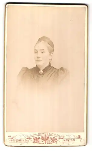 Fotografie A. Guesquin, Menton, Portrait hübsche Dame mit Hochsteckfrisur und Brosche am Kragen