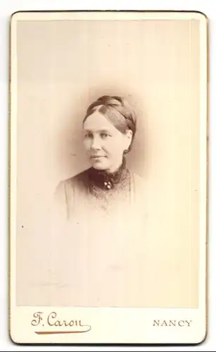 Fotografie F. Caron, Nancy, Portrait hübsche Dame mit Flechtfrisur und Brosche am Kragen