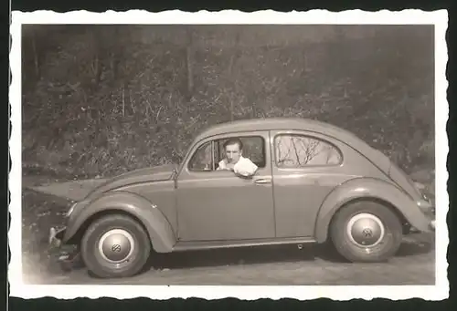 Fotografie Auto VW Käfer, junger Mann am Steuer des Volkswagen PKW's