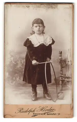 Fotografie Rudolph Hörder, Rathenow, kleines dunkelhaariges Mädchen mit Reifen