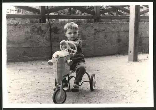 Fotografie Knabe fährt Dreirad mit Blechverkleidung