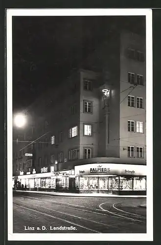 AK Linz a.D., Landstrasse mit Geschäften bei Nacht