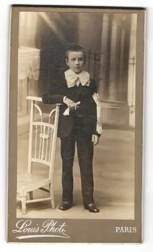 Fotografie Louis, Paris, frecher Bube im Anzug am Stuhl stehend