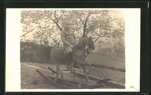 Foto-AK Bub auf Schaukelpferd im Garten